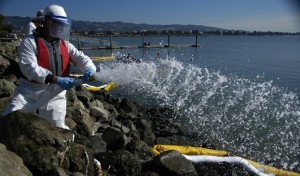 Corexit spray used in gulf image of boat onthe water where worker in caaontamination suit on bright sunny day